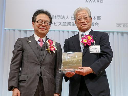 表彰式の様子（写真右から＝根岸孝成社長、世耕弘成経済産業大臣）